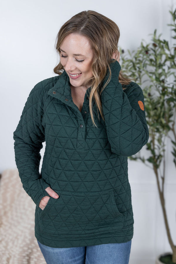 Woman wearing a green quilted jacket with a white background