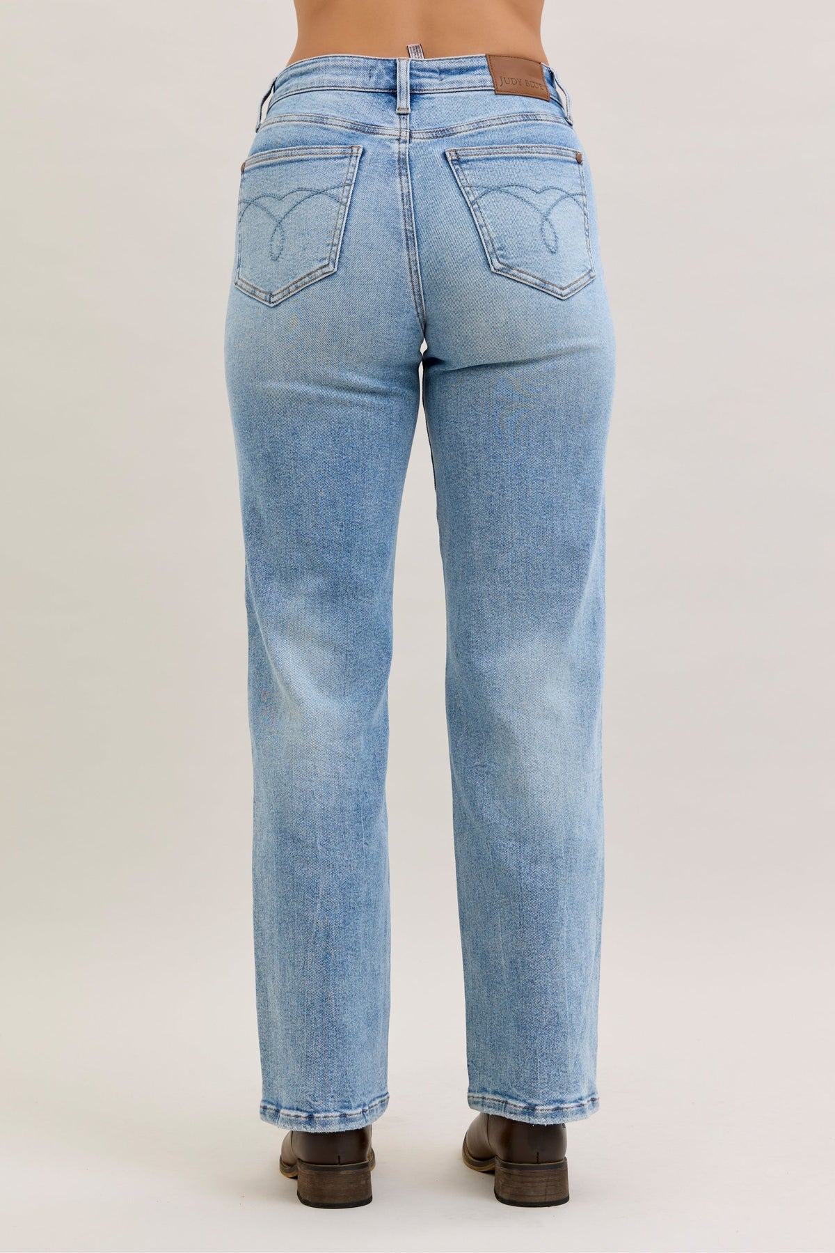 Light blue jeans worn by a person on a plain background