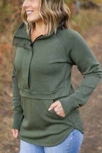Woman wearing a green pullover with a blurred natural background