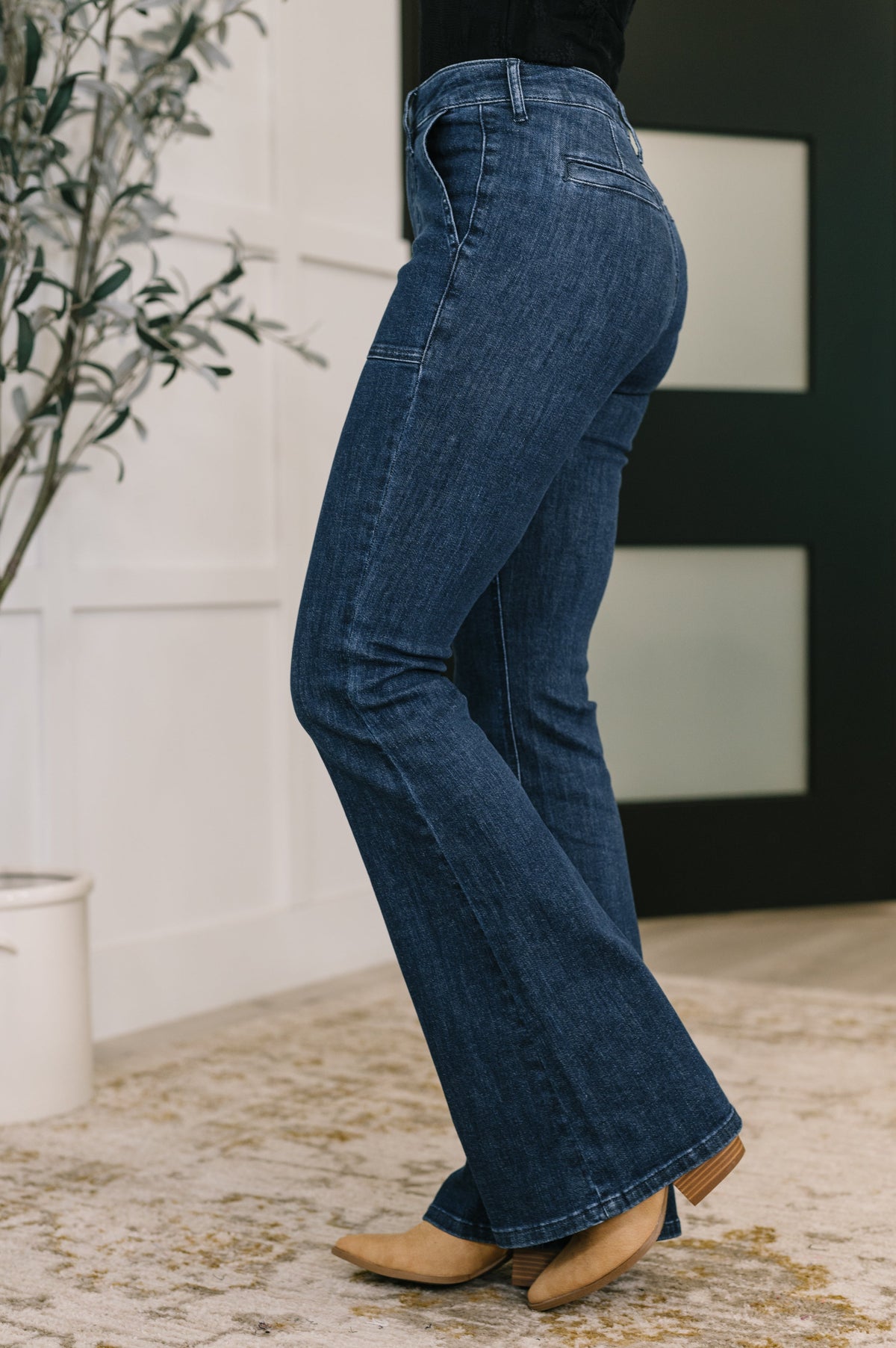 Person wearing blue jeans with a neutral background