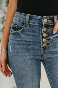 Close-up of blue jeans with decorative buttons on a blurred background