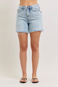 Light blue denim shorts worn by a person on a plain background