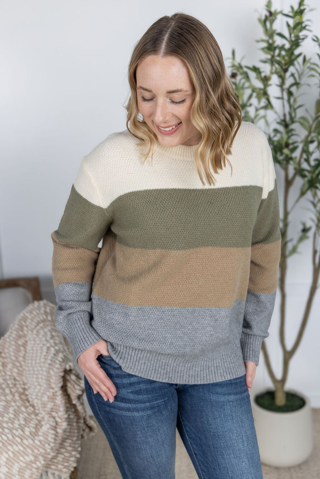 Woman wearing a color-blocked sweater in a home setting