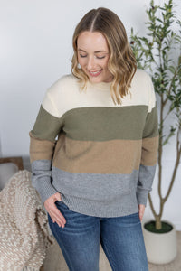 Woman wearing a color-blocked sweater in a home setting
