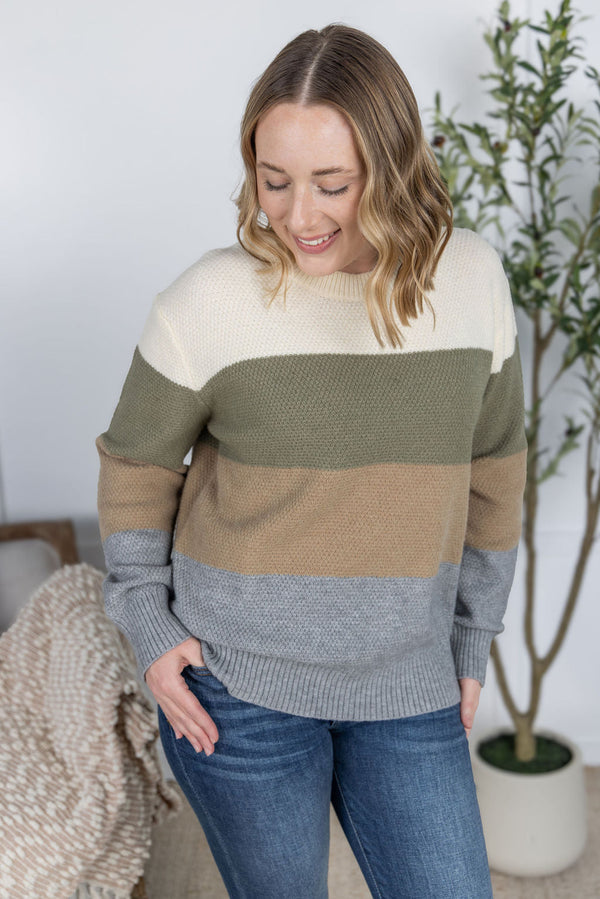 Woman wearing a color-blocked sweater in a home setting