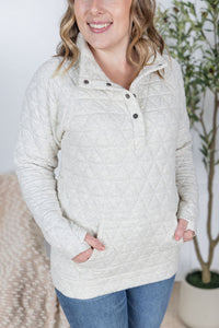 Woman wearing a beige quilted jacket with a white background