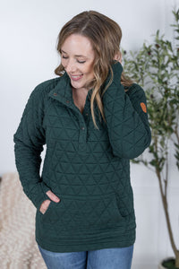 Woman wearing a green quilted jacket with a white background