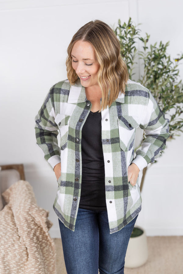 Woman wearing a plaid shirt in a home setting