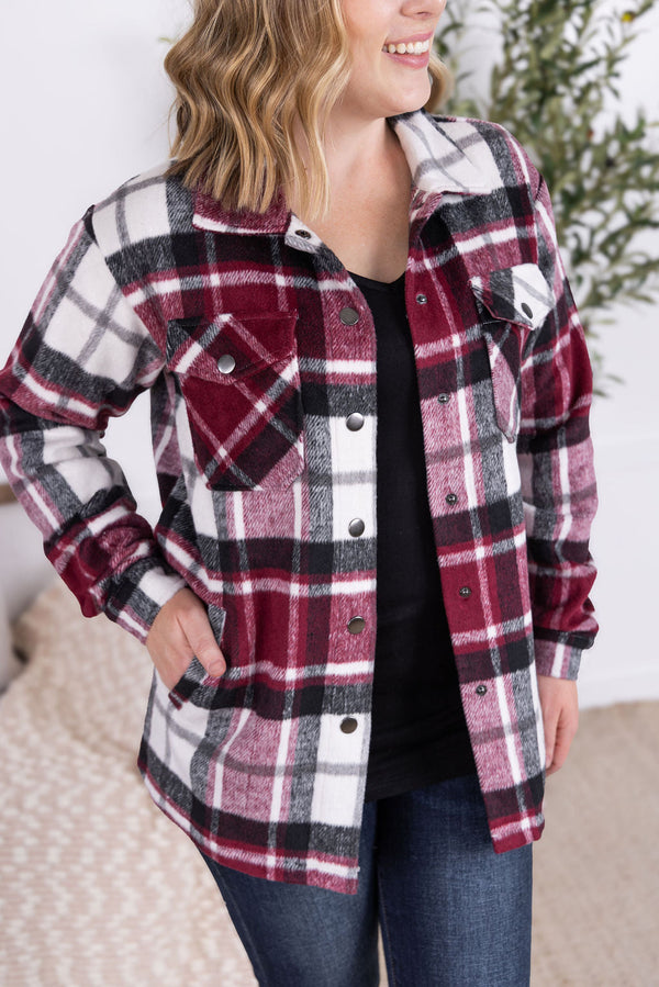 Woman wearing a plaid shirt with a blurred background