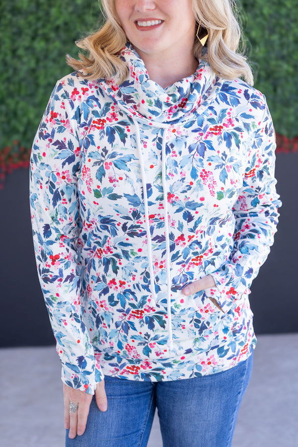 Woman wearing a colorful floral jacket with a blurred green background
