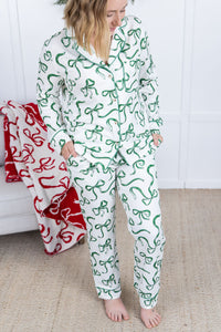 Person wearing a green and white patterned onesie standing in a room with a red blanket.