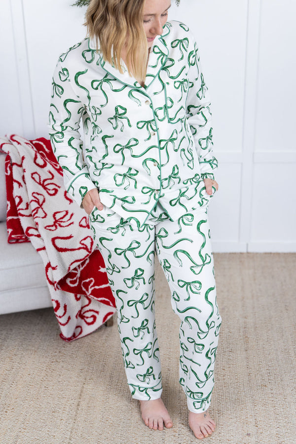 Person wearing a green and white patterned onesie standing in a room with a red blanket.
