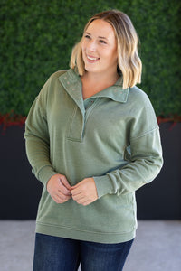 Woman wearing a green pullover with a blurred green background