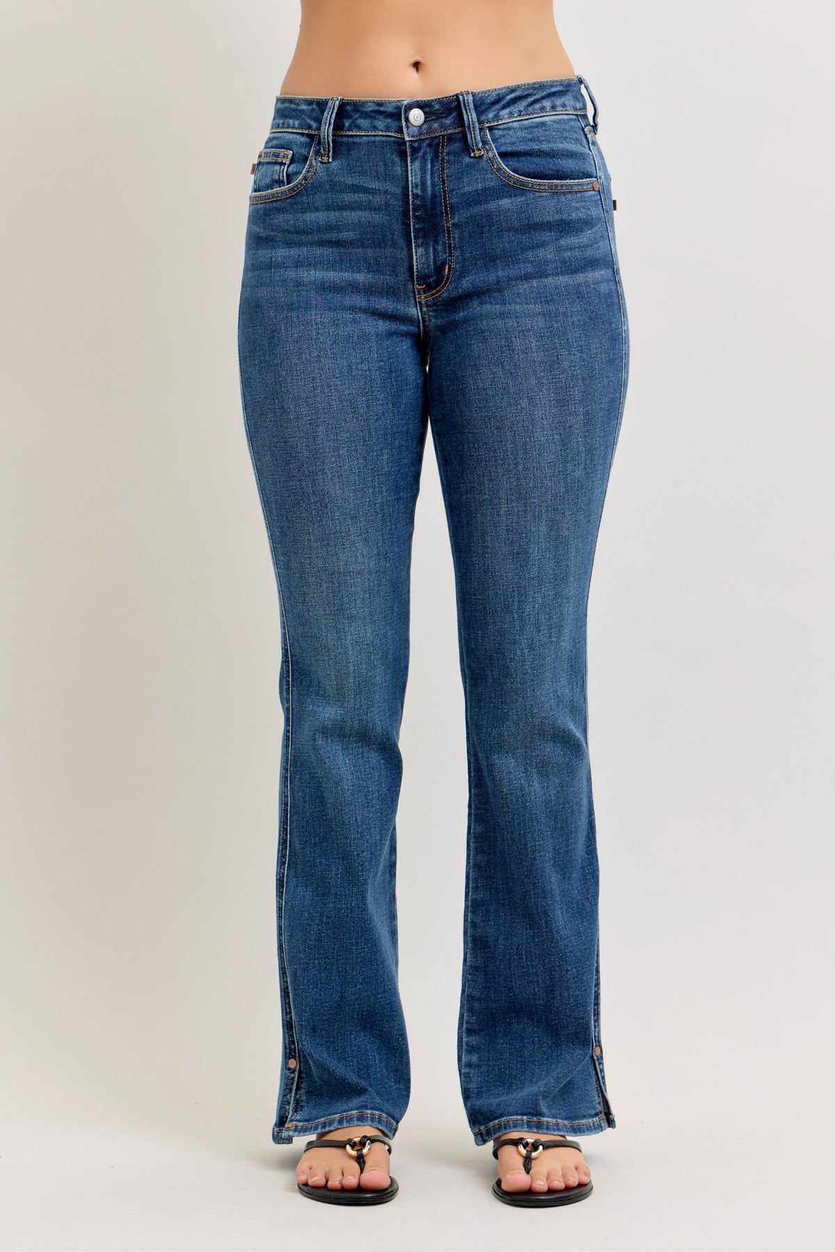 Blue jeans worn by a person on a plain background