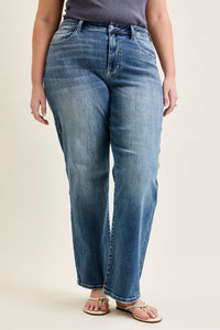 Person wearing blue jeans on a plain background