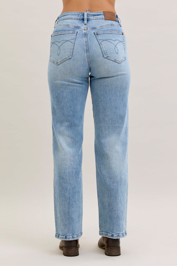 Light blue jeans worn by a person on a plain background