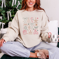 Person wearing a cream sweatshirt with Christmas-themed designs, sitting in front of a decorated Christmas tree.