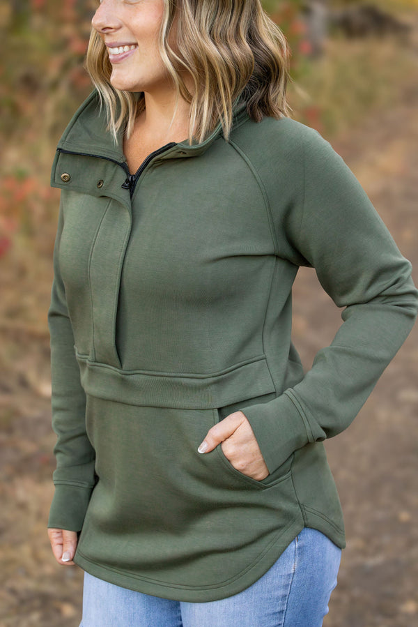 Woman wearing a green pullover with a blurred natural background