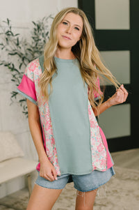 Woman wearing a light blue top with floral sleeves in a casual setting