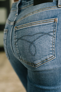 Close-up of blue jeans with a brand logo on the pocket.