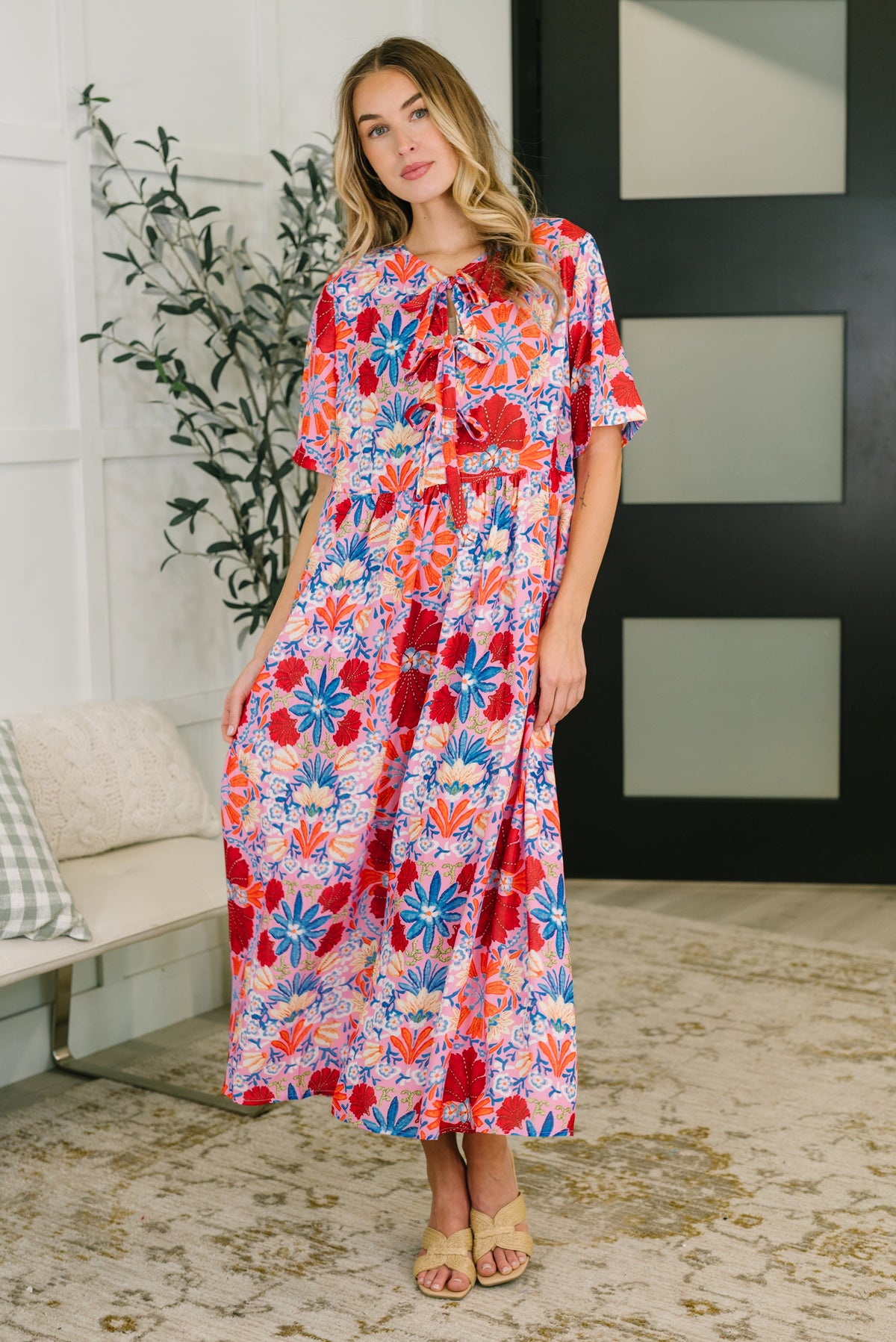 Woman wearing a colorful floral dress in an indoor setting
