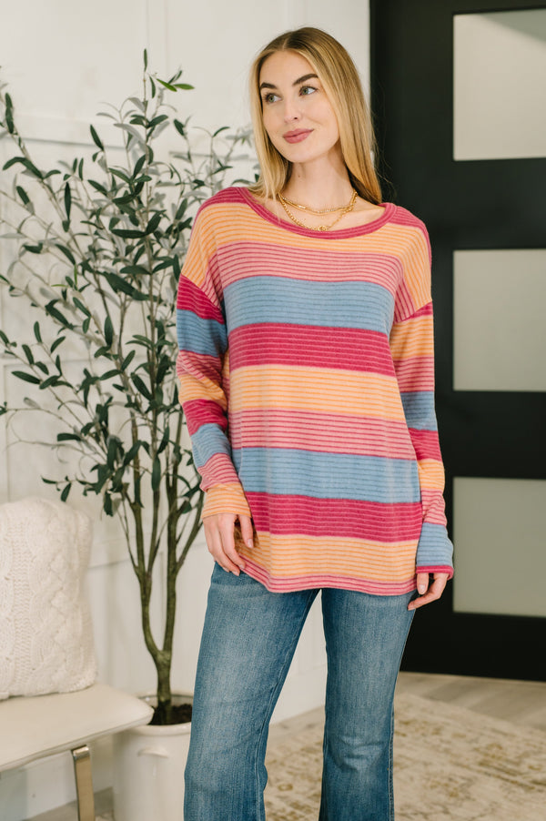 Woman wearing a colorful striped sweater in a home setting