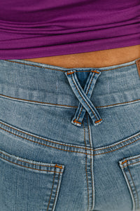 Close-up of blue jeans with a purple top