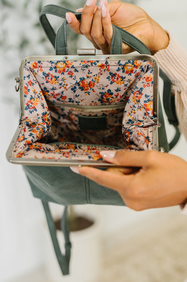 Floral-patterned handbag held by a person with a blurred background