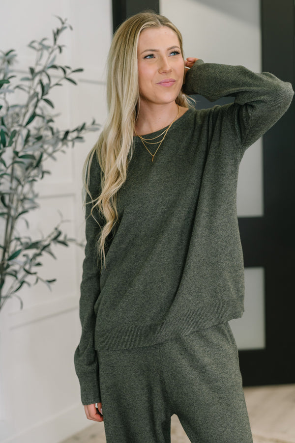 Woman wearing a green loungewear set indoors with a plant in the background