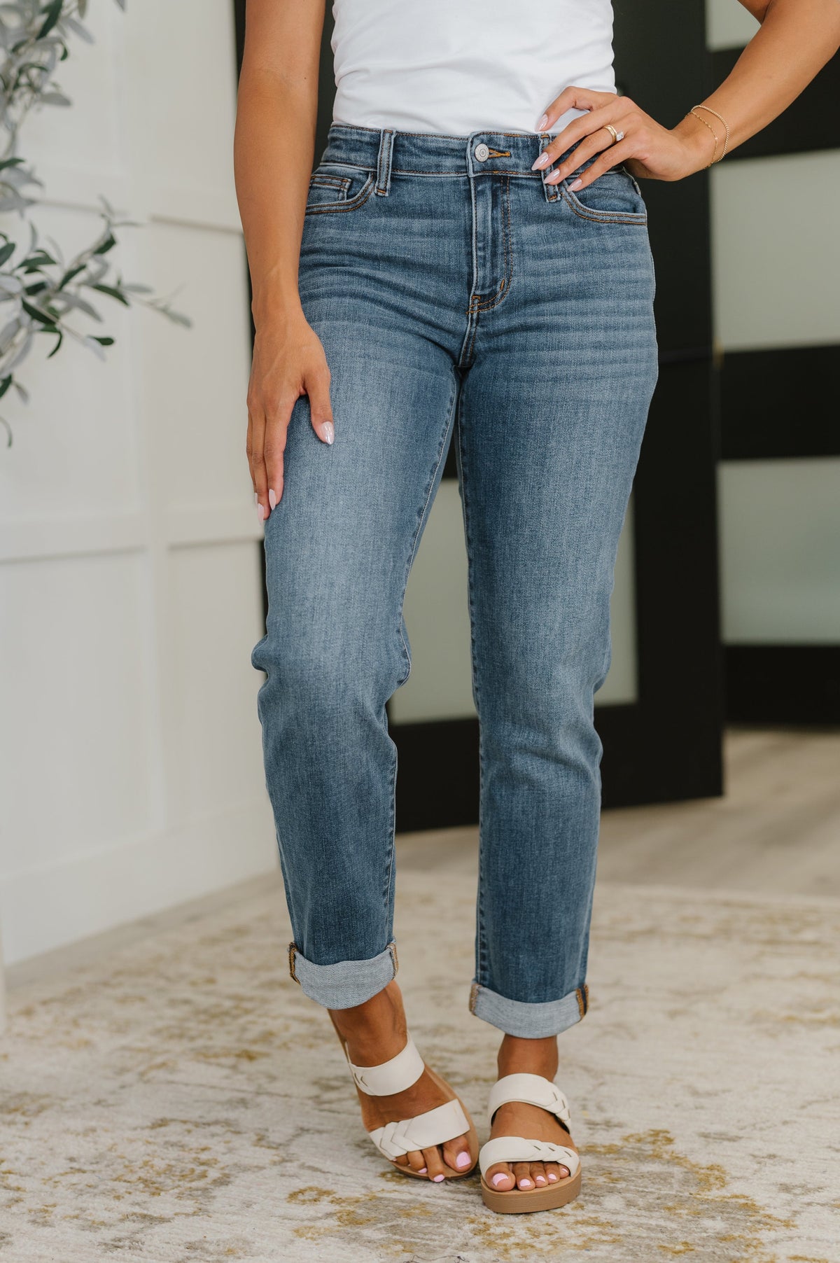Person wearing blue jeans and white sandals indoors