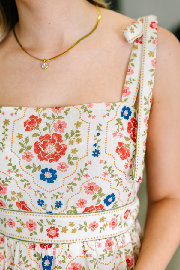 Floral dress with a gold necklace on a blurred background