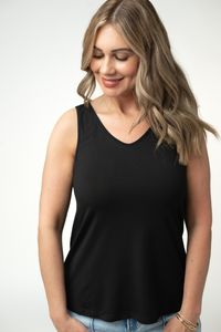 Woman wearing a black tank top against a white background