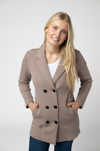 Woman wearing a beige double-breasted coat on a white background