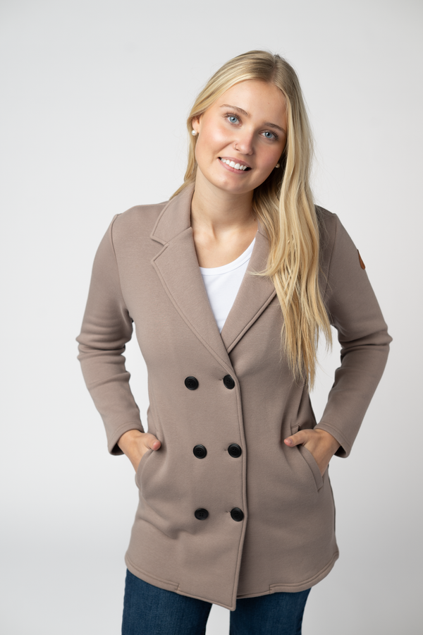 Woman wearing a beige double-breasted coat on a white background