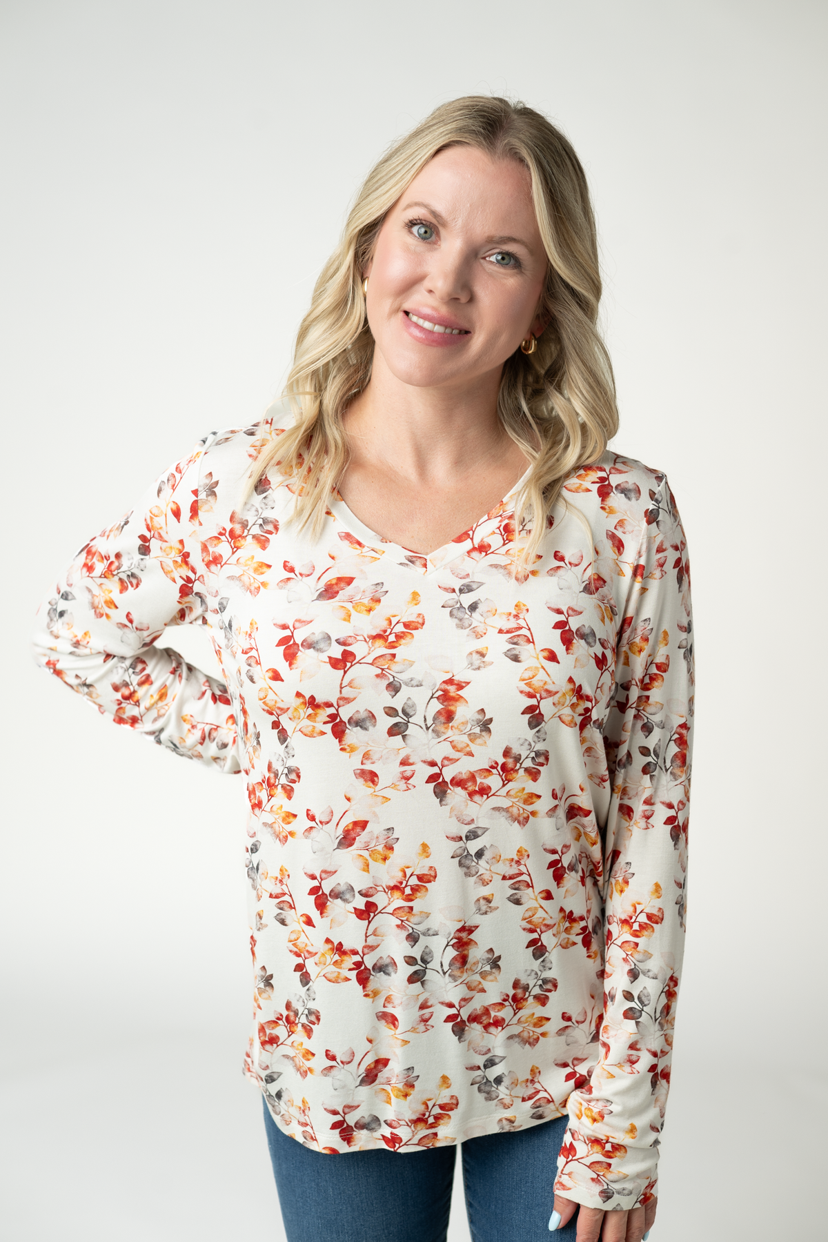 Woman wearing a floral long-sleeve top against a white background