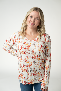 Woman wearing a floral long-sleeve top against a white background
