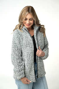 Woman wearing a gray sherpa jacket on a white background