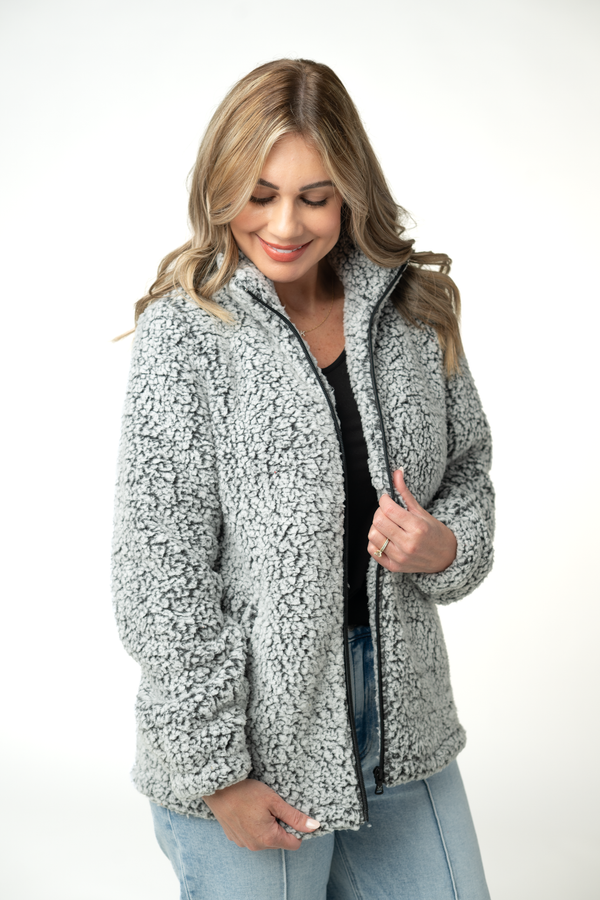 Woman wearing a gray sherpa jacket on a white background