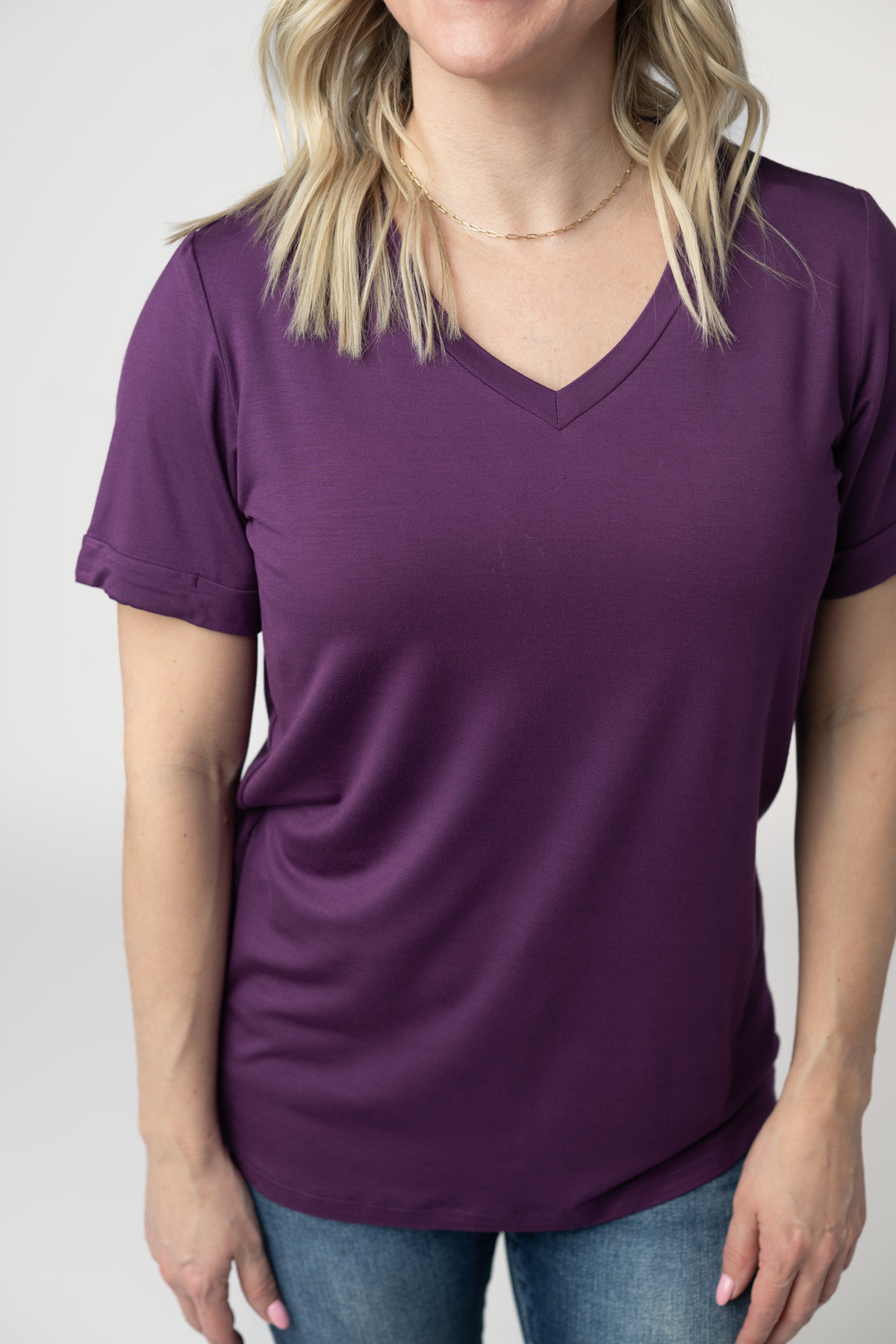 Person wearing a purple t-shirt against a plain background