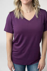 Person wearing a purple t-shirt against a plain background