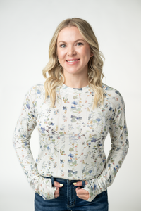 Woman wearing a floral blouse against a white background