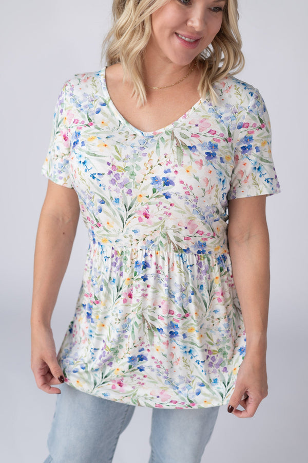 Woman wearing a floral print top against a plain background