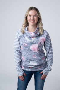 Woman wearing a floral and striped long-sleeve top against a plain background