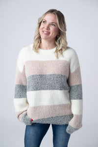 Woman wearing a striped sweater with a plain background