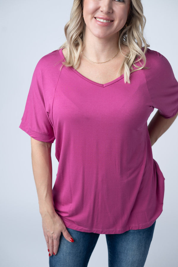 Woman wearing a pink t-shirt and blue jeans on a white background