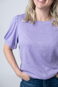 Woman wearing a purple t-shirt against a plain background