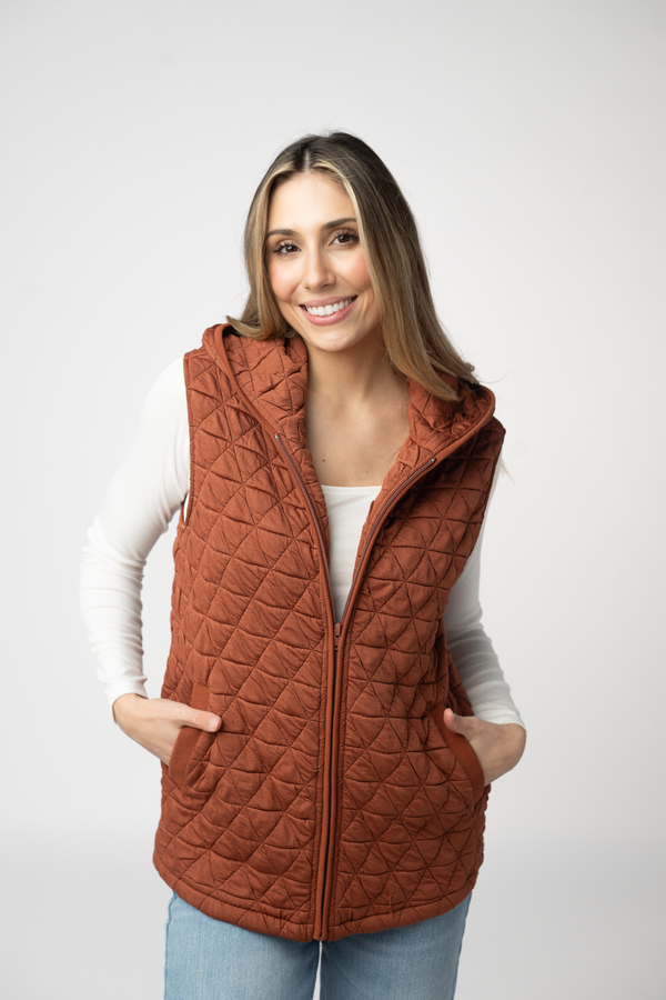 Woman wearing a brown quilted vest on a white background