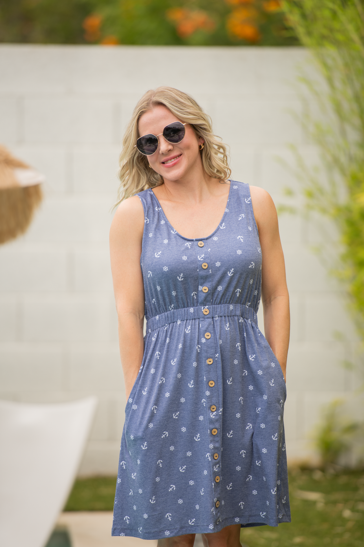 Woman wearing a blue dress with a floral pattern outdoors.
