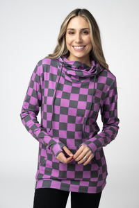 Woman wearing a purple and gray checkered dress with a cowl neck on a white background