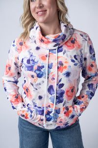 Woman wearing a floral-patterned hoodie against a plain background